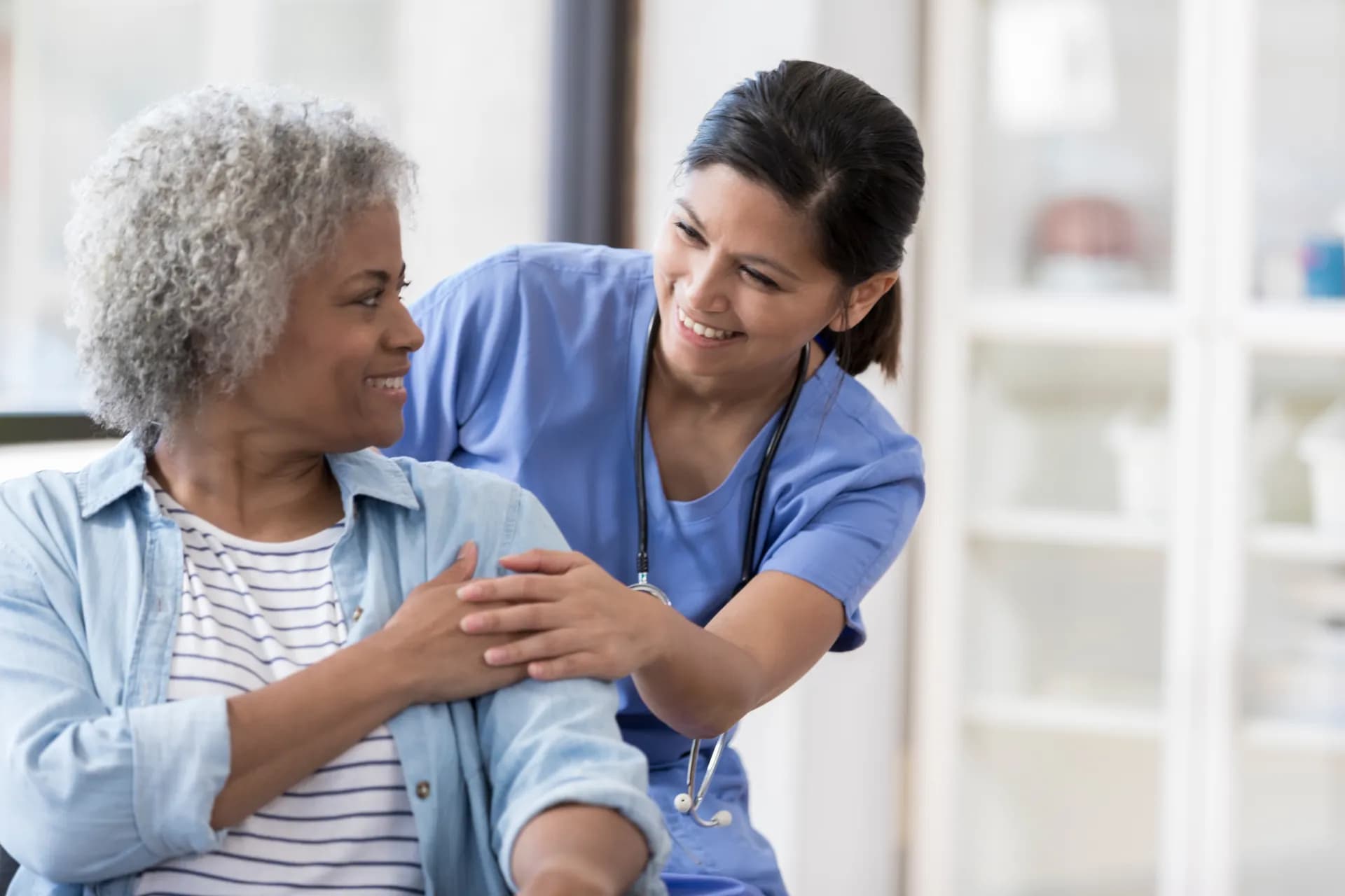 Pflegefachperson betreut ältere Patientin — Empathie und Fachkompetenz